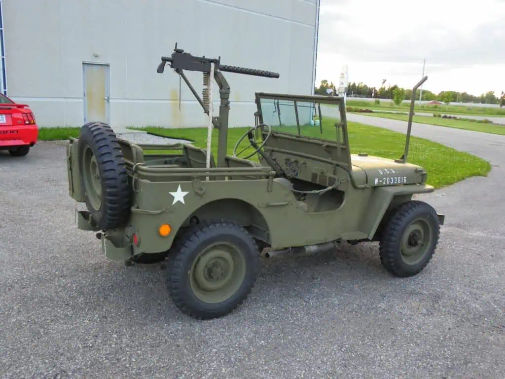 Antique military jeep with mounted machine gun, vintage military vehicle, rugged off-road American military Jeep, historic military automotive, WWII era military transport.
