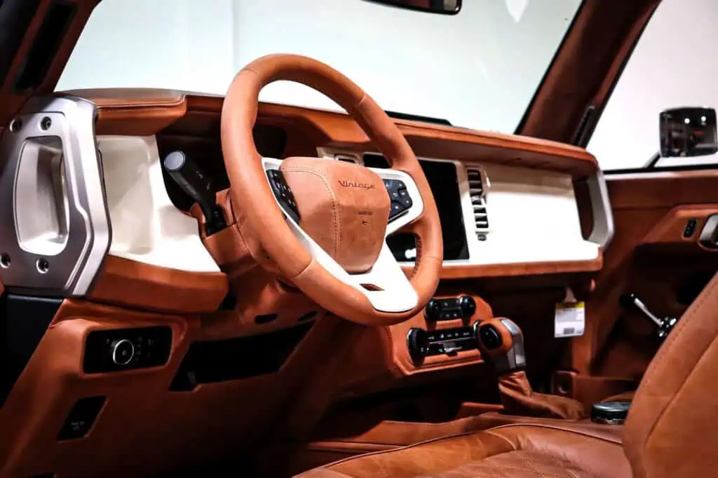 Luxurious vintage-inspired car interior with tan leather seats and modern controls, showcasing a blend of classic and contemporary automotive design.