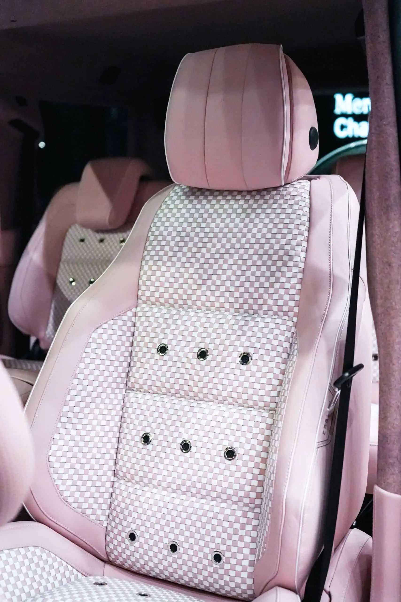 Stylish pink modern vintage car seat with checkered upholstery, perfect for chic interior decor or themed automotive settings.